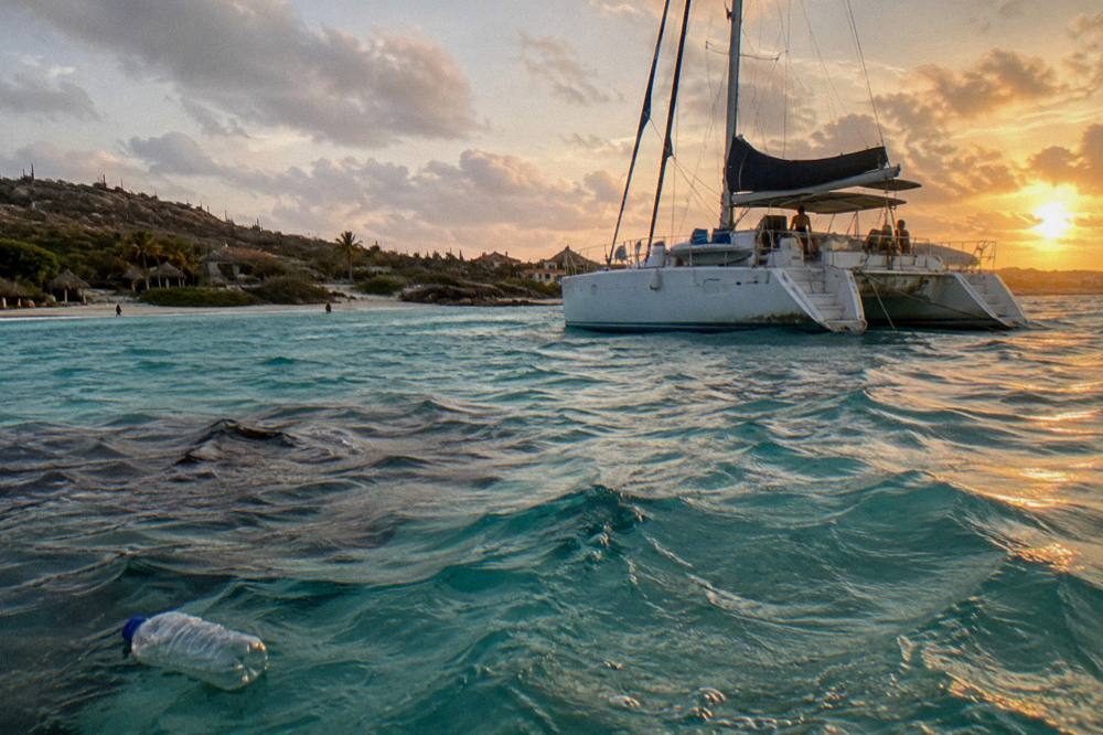 A catamaran anchored over turquoise water near a reef in Aruba